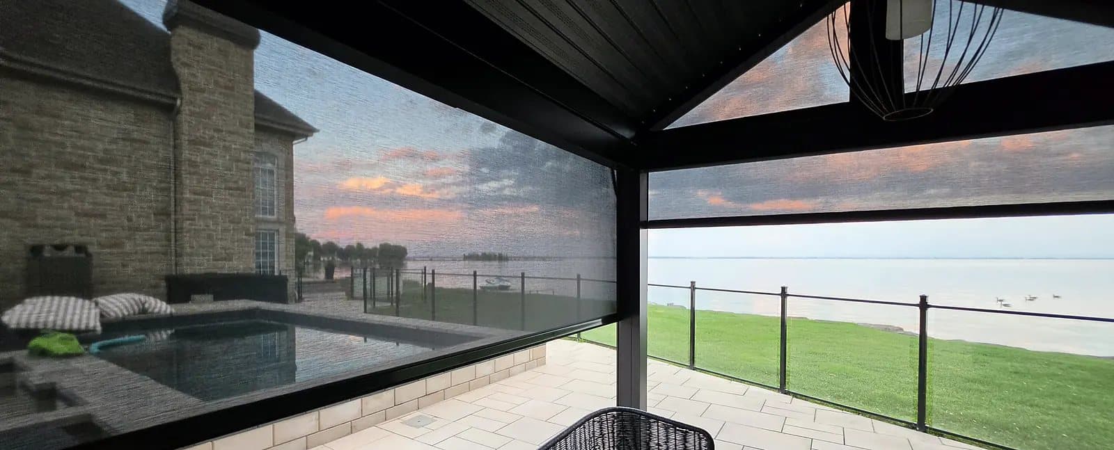 Pool house enclosed by exterior solar shades with side tracks, at sunset, Vaudreuil-Soulanges