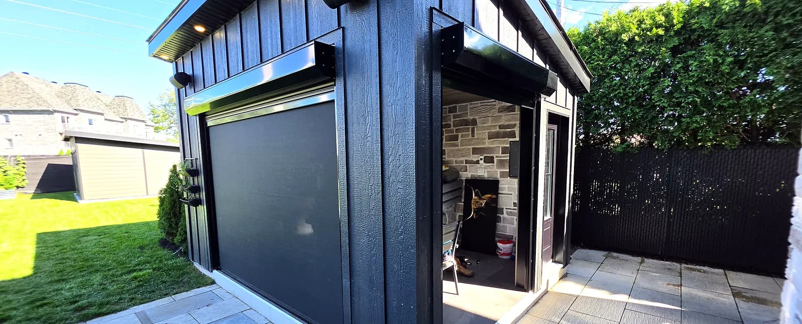 Deux volets roulants et deux moustiquaires motorisées, l'un derrière l'autre, pour la cuisine extérieure d'un pavillon de piscine à Chambly