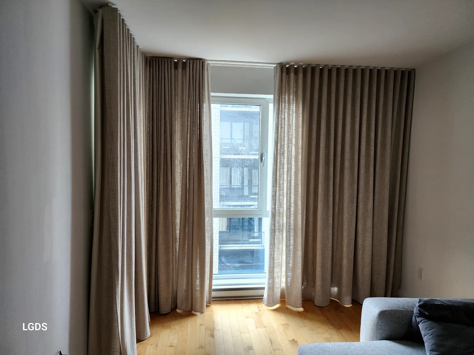 Rideaux de lin Ripple Fold pleine hauteur filtrant la lumière d'un salon, Montréal