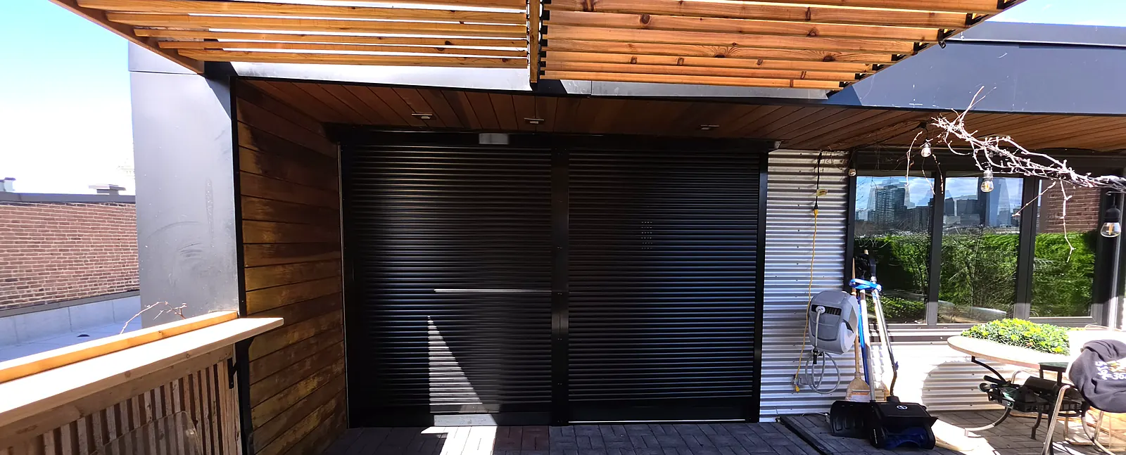 Black security roller shutter on a rooftop terrace door, Montreal