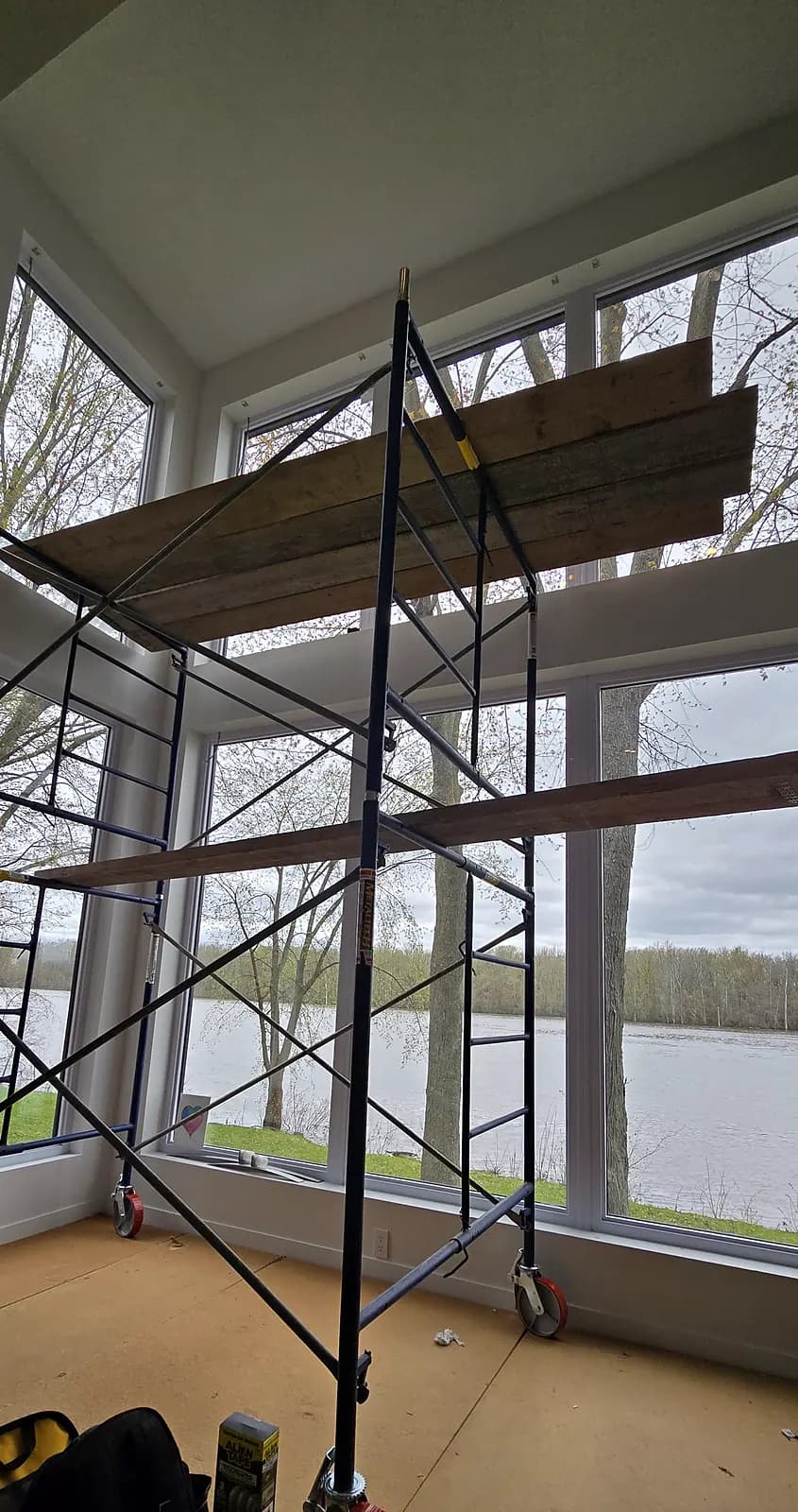 Échafaudage monté sur des panneaux qui protègent le plancher, pour installer des toiles en hauteur dans une verrière, Rive-Nord